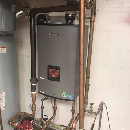 Technician checking boiler pressure gauge in amelia oh home